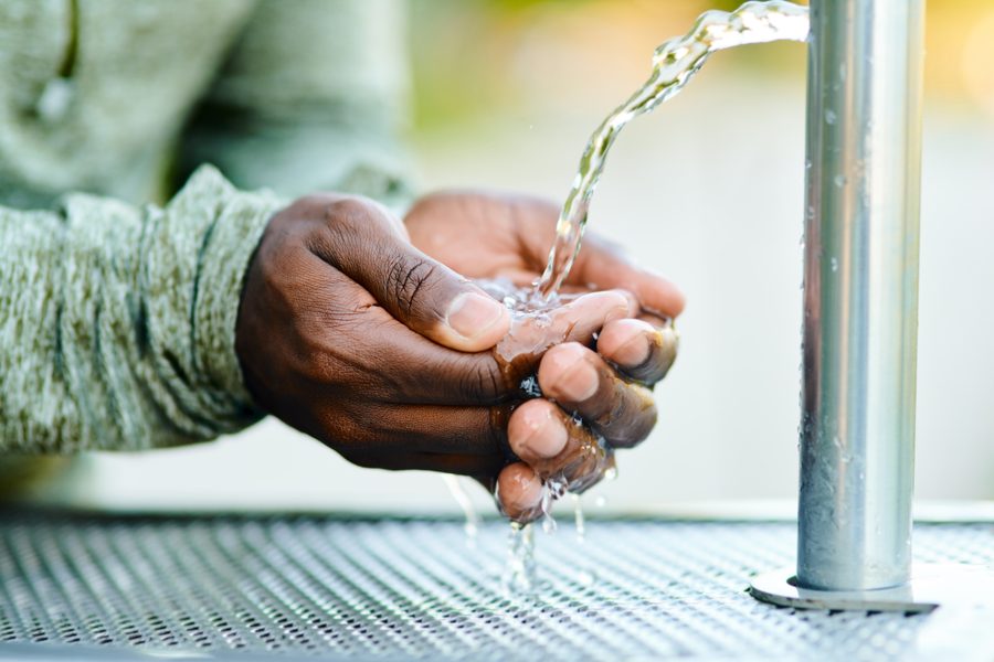 Person collecting clean water from a community tap
